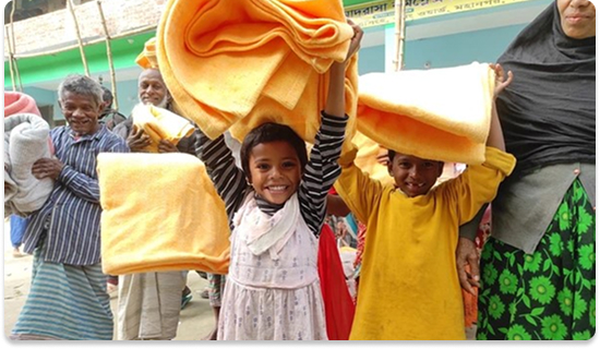 Children receiving blankets from SPAR organization